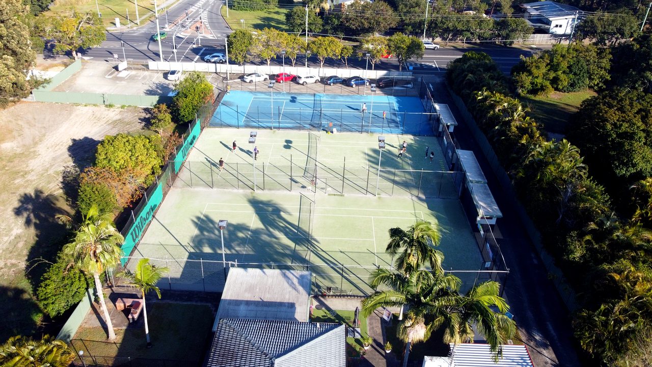 Looking down on all three floodlit courts at Logan Tennis Club on a sunny morning