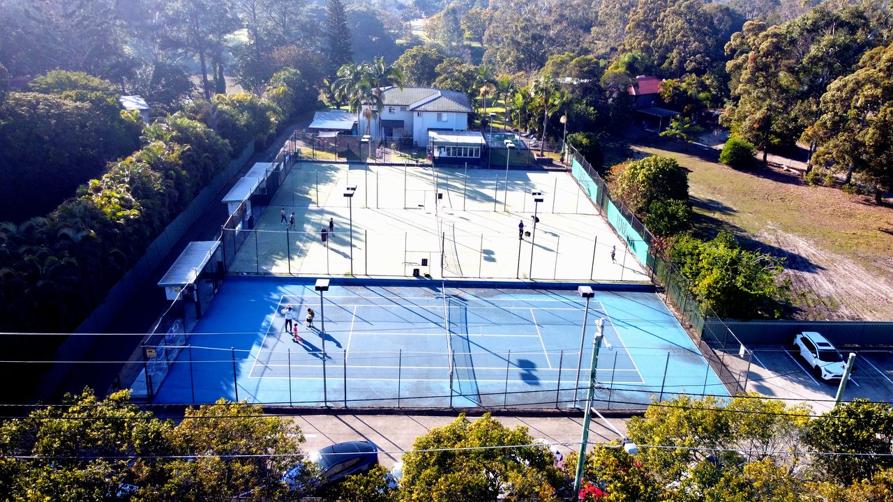 The blue hard court, clubhouse and parking at Logan Tennis Club